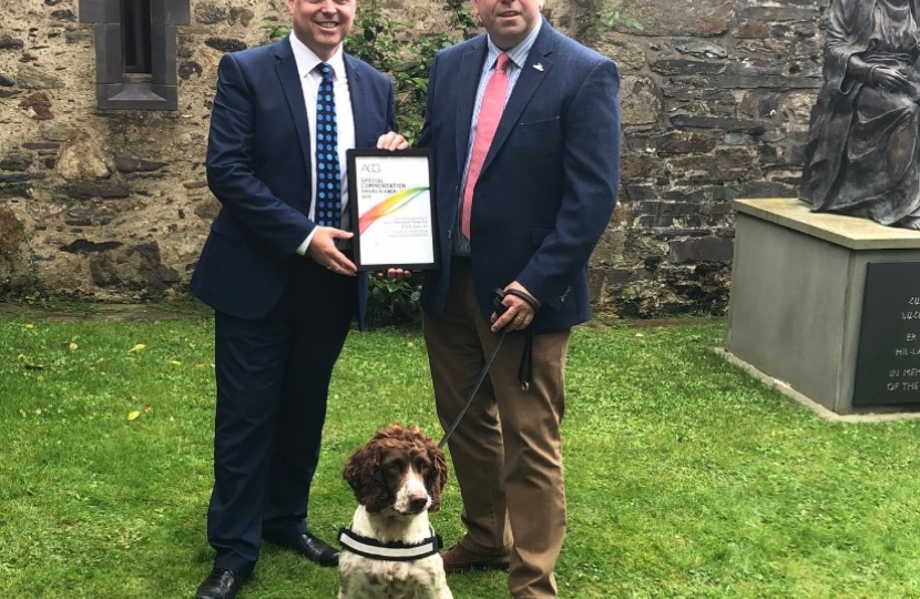 Paul Davies AM is pictured with Stuart Phillips and Scamp from B.W.Y. Canine Ltd.,/ Paul Davies AC gyda Stuart Phillips a Scamp o B.W.Y. Canine Ltd.,
